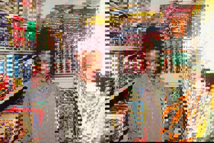 a woman in a grocery store holding a bag of pringles