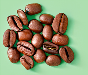 A pile of coffee beans on a light green background.