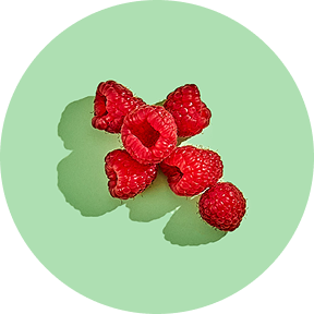 Cluster of fresh raspberries on a light green background.